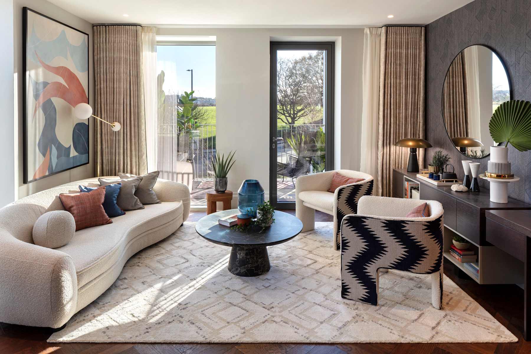 A living room with a white sofa, coffee table and floor to ceiling windows